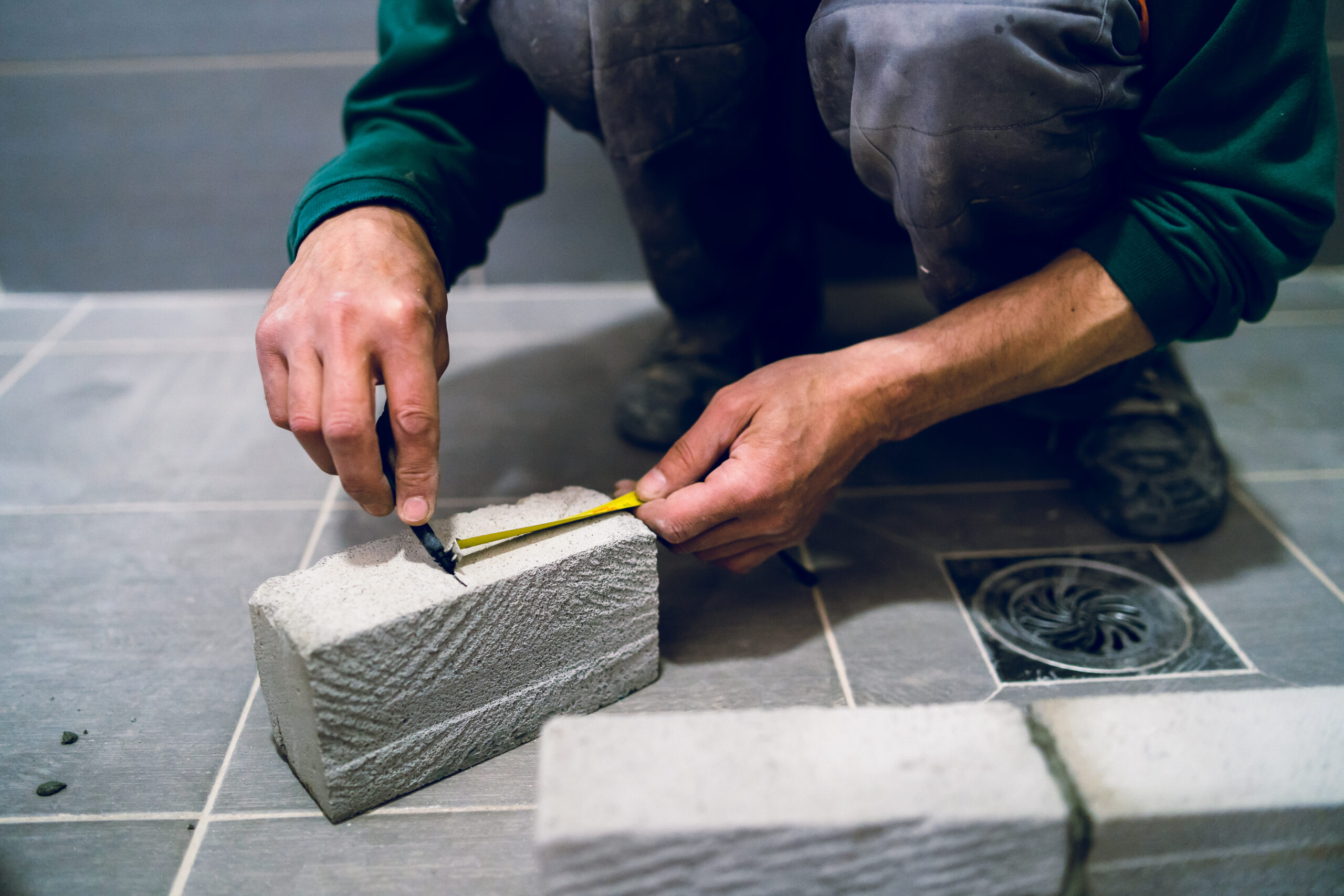 construction worker craftsman measuring brick